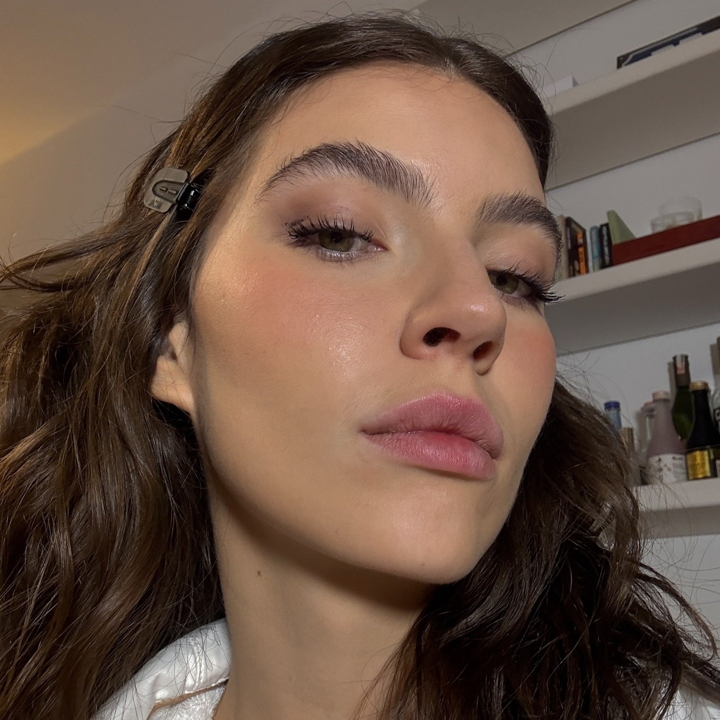 Selfie de uma mulher de cabelos escuros, com o rosto próximo à câmera.