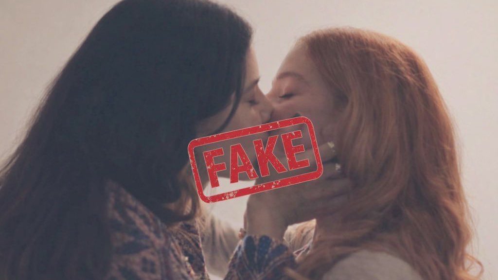 Duas mulheres se beijando, com a palavra FAKE sobreposta em vermelho.