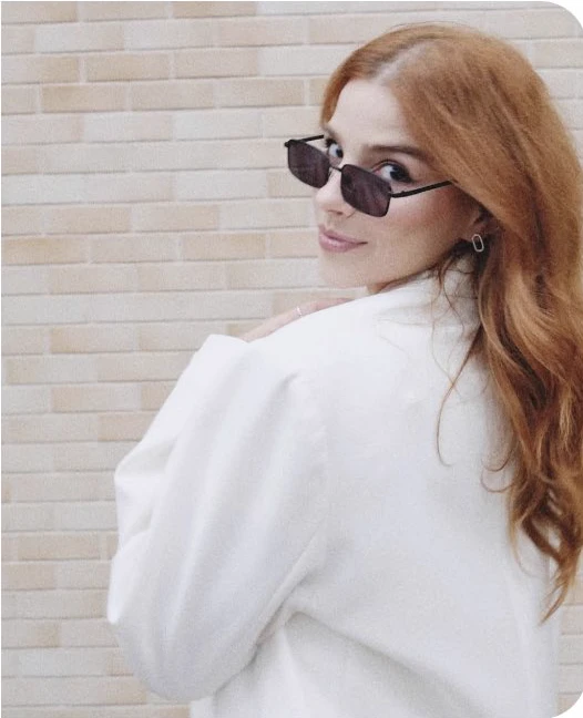 Eduarda Fragoso usando roupa branca e óculos escuros.