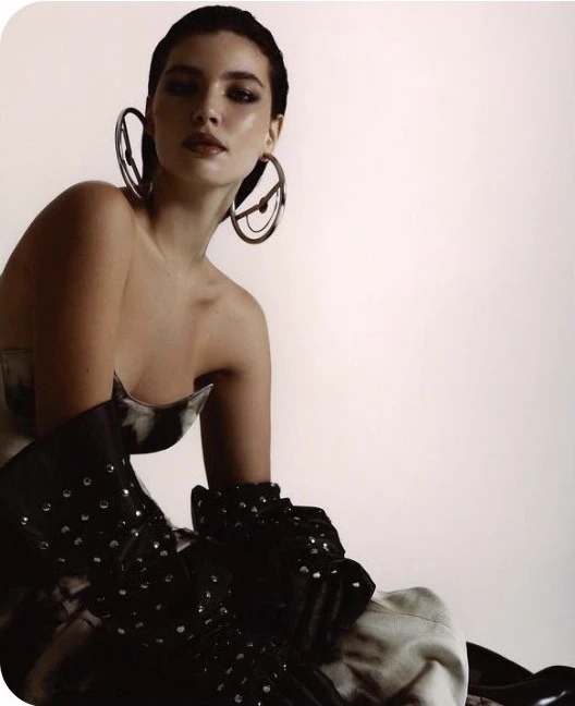 Lorena Ferette usando roupa escura e brincos grandes.